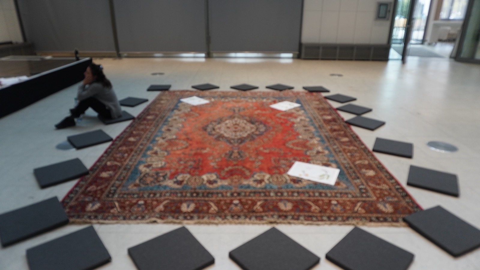 Sitzkissen um einen großen orientalischen Teppich in einem hellen Foyer